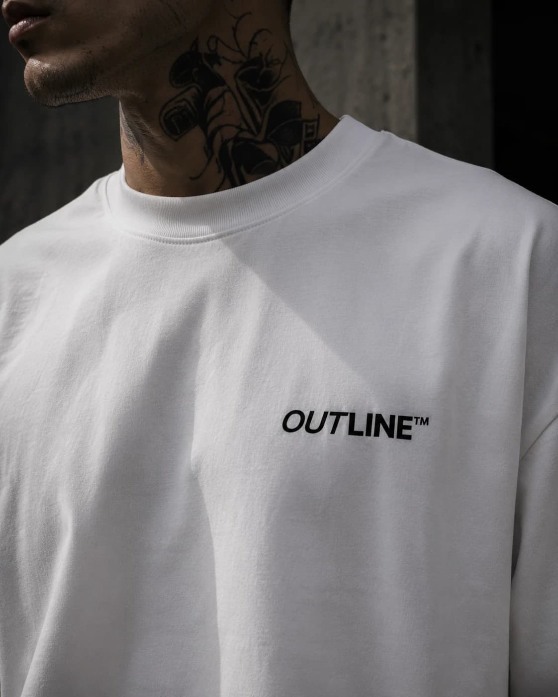 Close-up of the OUTLINE chest print on white heavyweight cotton
