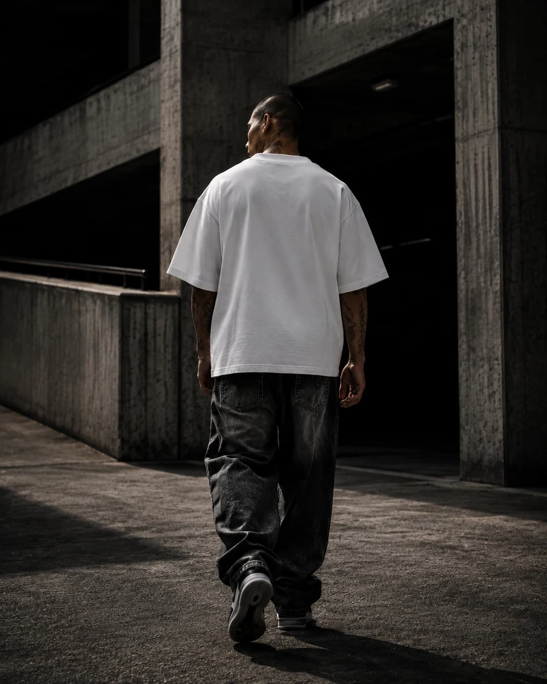 Back view — model walking toward a dark concrete entrance